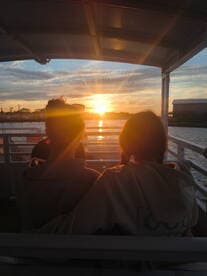 Two friends enjoy a stunning sunset view from the deck of a boat, creating a perfect backdrop for memorable moments on the water.