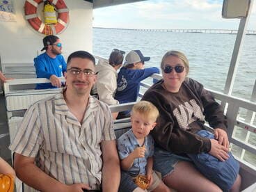 A family enjoys a boat ride together, with a child snacking and adults relaxing — a perfect moment for creating lasting memories on the water.