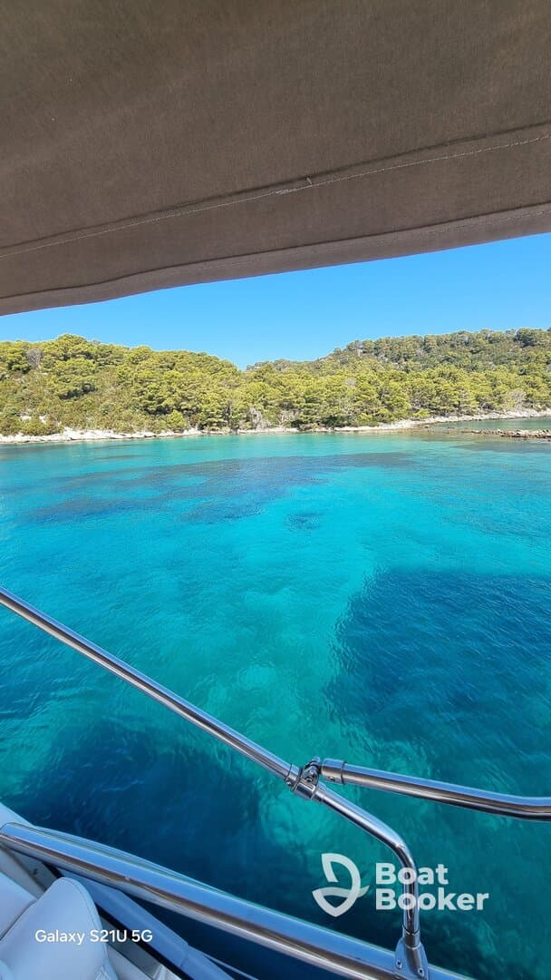 A stunning view of turquoise waters and lush greenery from a boat, showcasing the beauty of the coastline — perfect for nature lovers and boating enthusiasts.