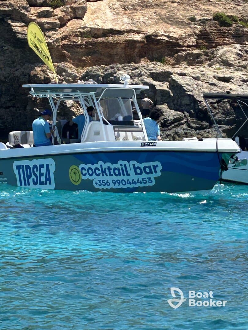 A vibrant speedboat named 'TIPSEA' serves as a cocktail bar, showcasing a lively atmosphere with guests onboard, perfect for enjoying refreshing drinks on the water.