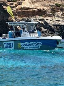 A vibrant speedboat named 'TIPSEA' serves as a cocktail bar, showcasing a lively atmosphere with guests onboard, perfect for enjoying refreshing drinks on the water.