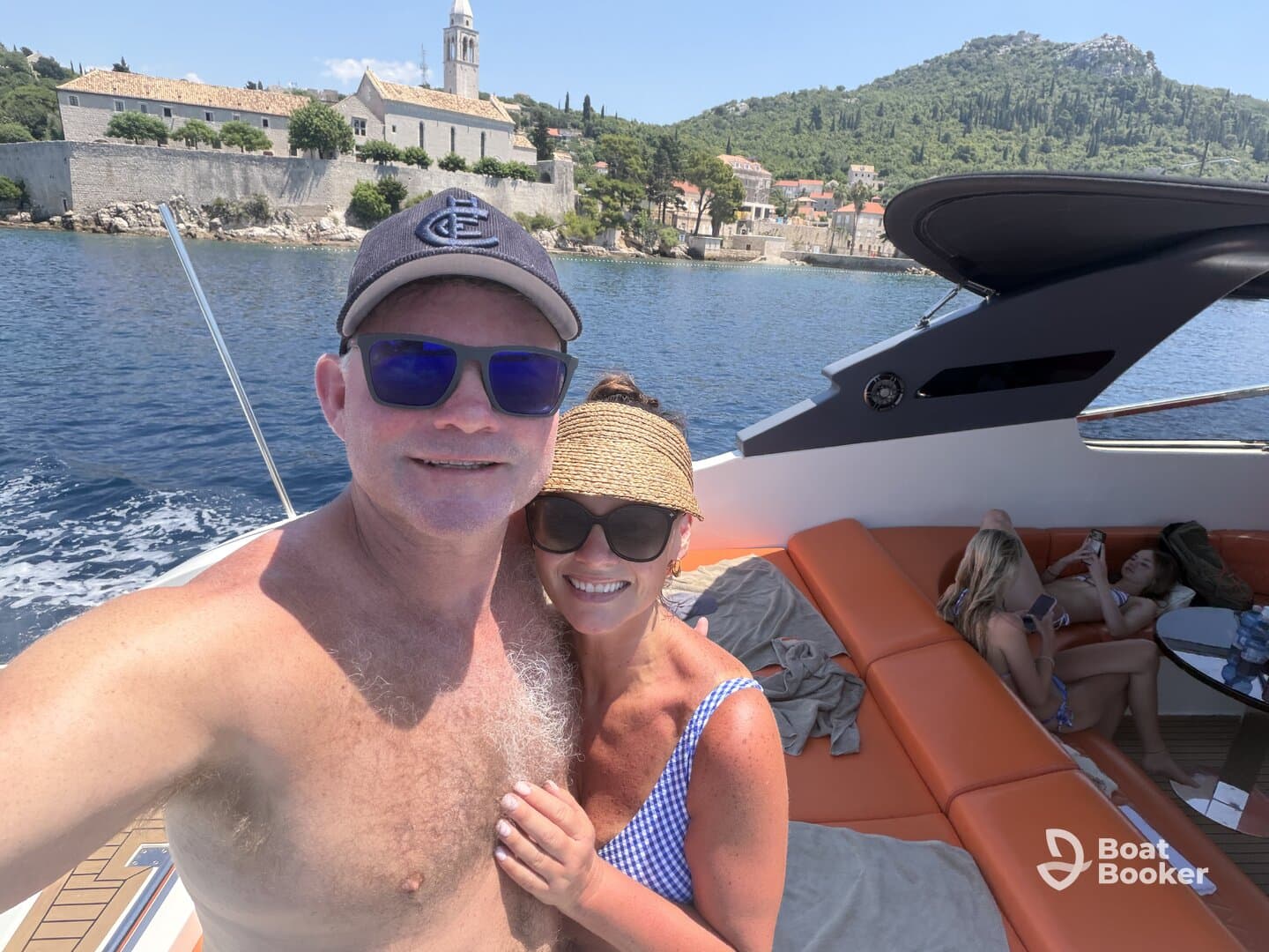A couple enjoys a sunny day on a boat, with scenic views in the background — perfect for memorable outings and celebrations on the water.