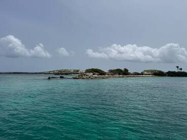 A serene view of a secluded island surrounded by clear turquoise waters, perfect for exploring the natural beauty of coastal destinations.