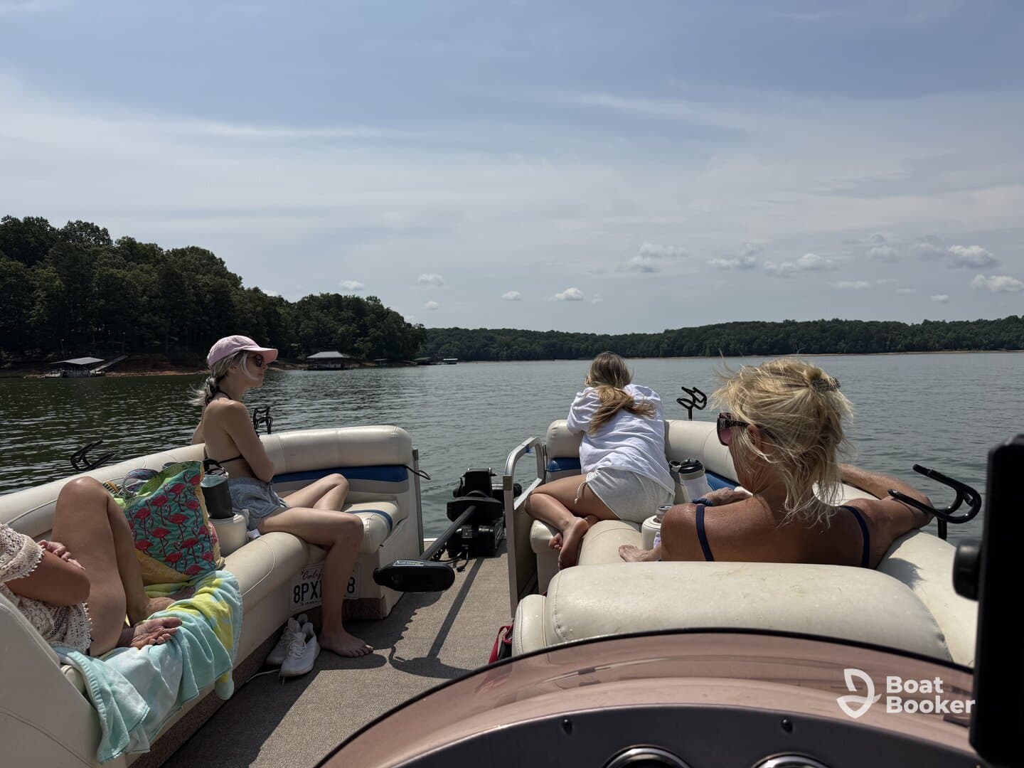 A group enjoys a relaxing day on a pontoon boat, taking in the serene lake views — perfect for family outings and summer fun.