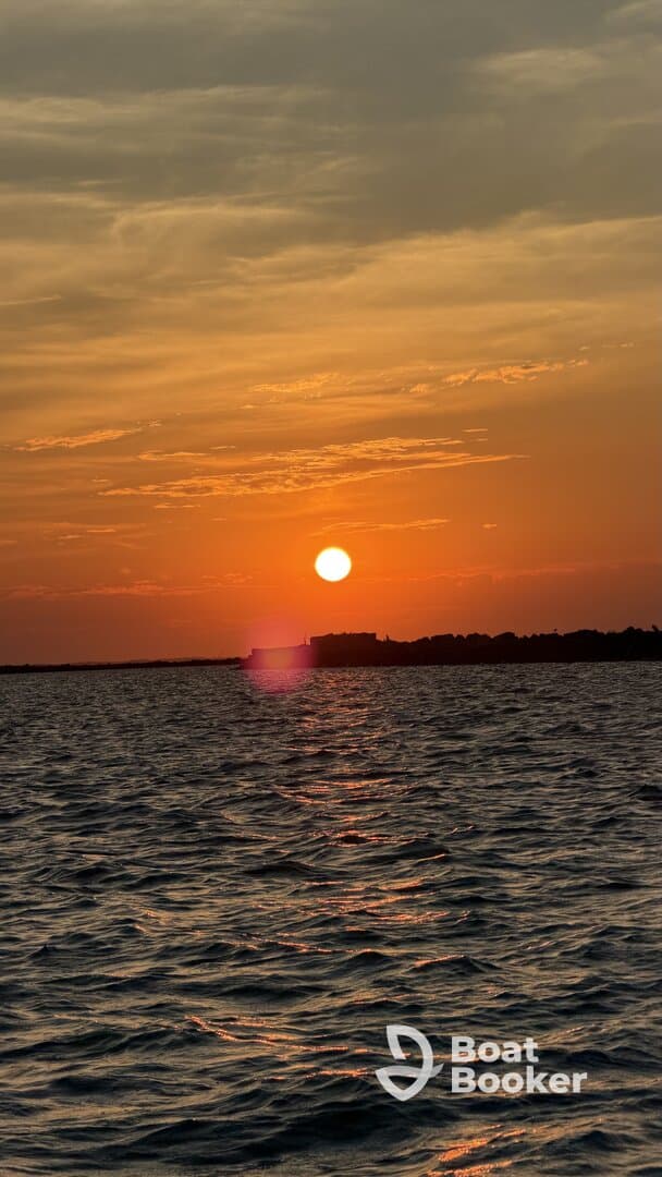 A stunning sunset over calm waters, capturing the serene beauty of the evening sky — perfect for romantic boat cruises or peaceful reflections.