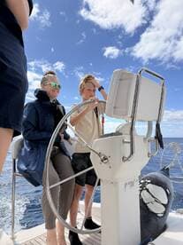 A family enjoys a fun moment on the water as a child takes the helm of the boat, creating lasting memories on their adventure.