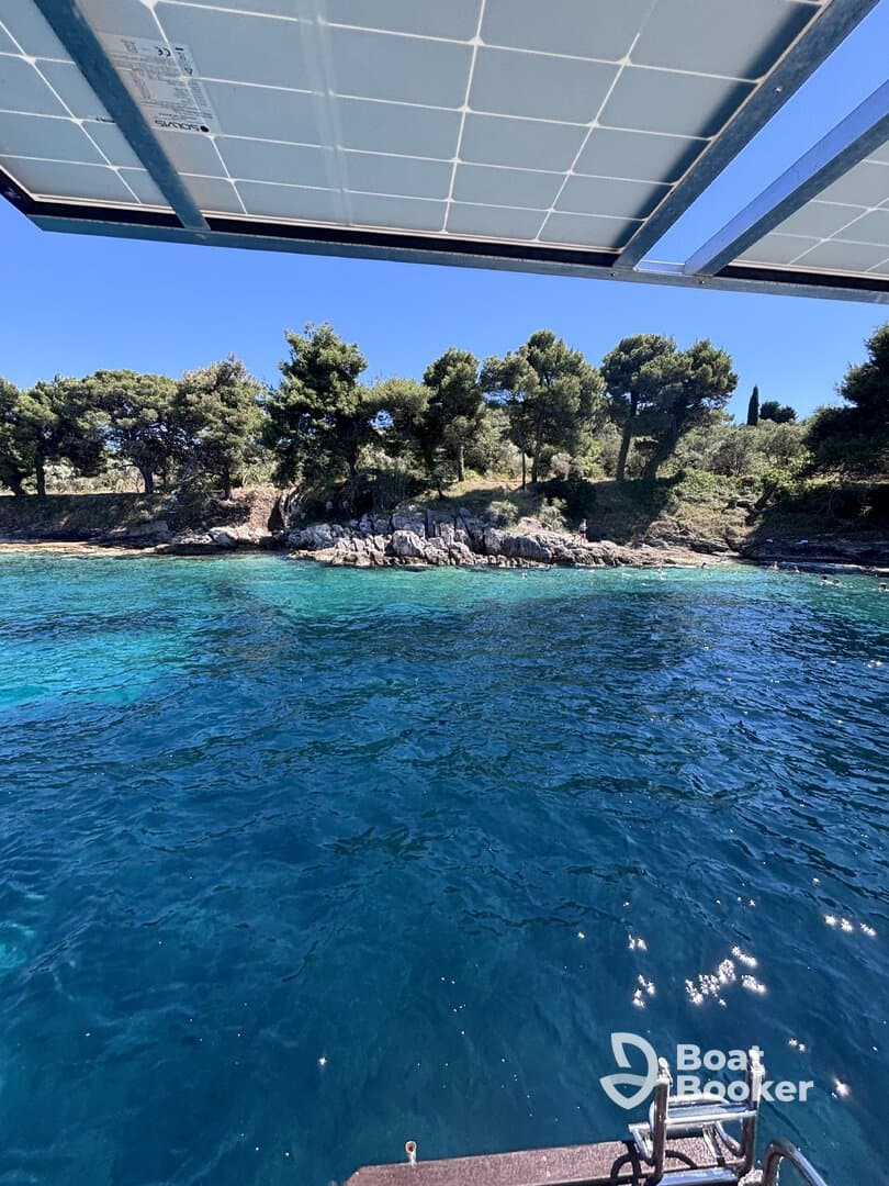 A serene view from a boat showcasing clear turquoise waters and a rocky shoreline, perfect for exploring coastal landscapes.