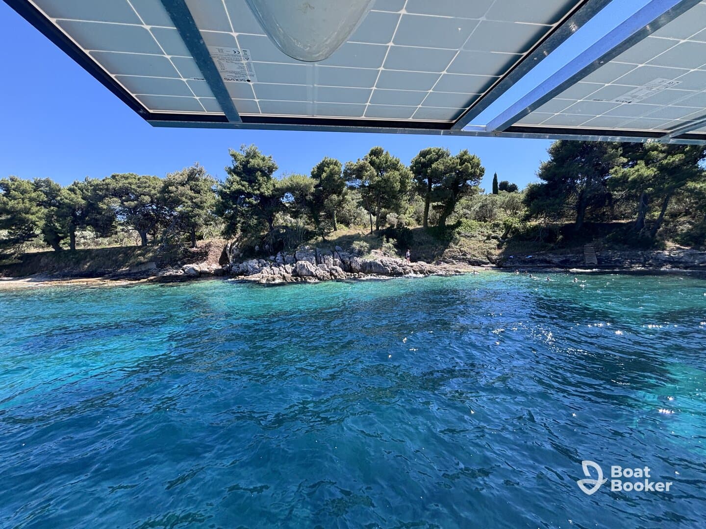 A picturesque view of a rocky coastline with clear turquoise waters, showcasing a perfect summer day for swimming and relaxation.