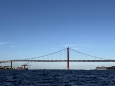 A stunning view of a prominent bridge spanning the water, showcasing the beauty of the surrounding landscape and maritime activity.