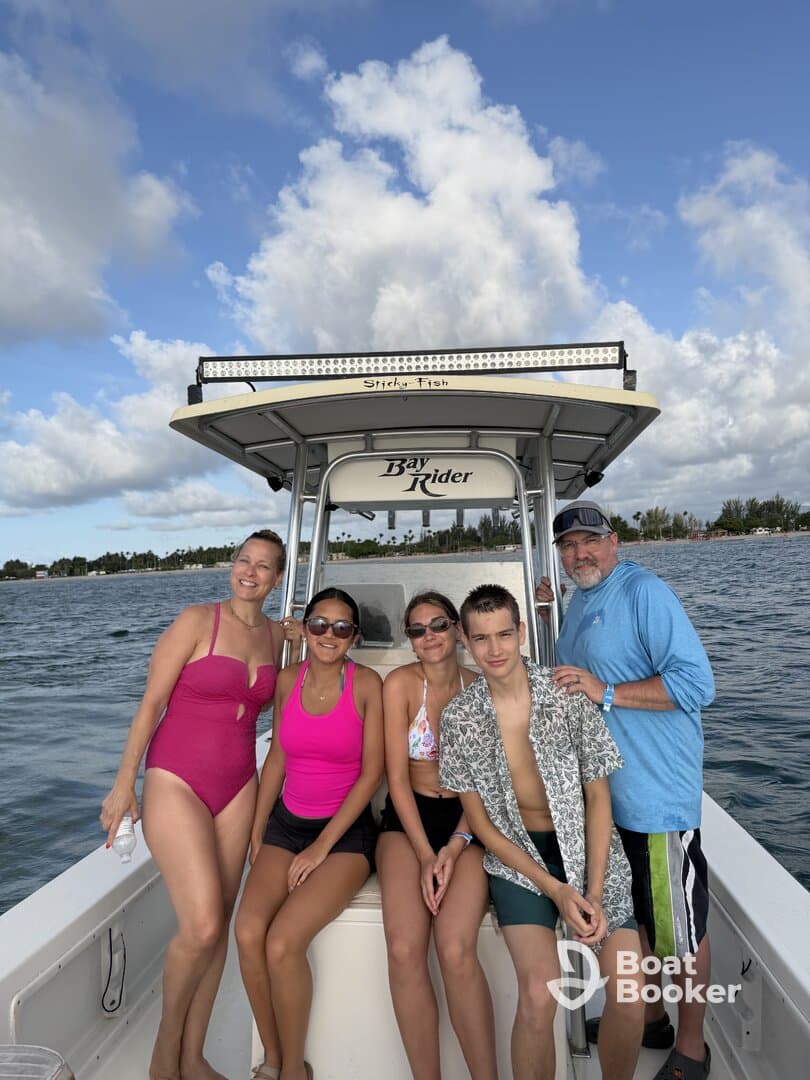 A cheerful group of family members poses on a Bay Rider boat, enjoying a sunny day on the water — perfect for family outings and adventures.