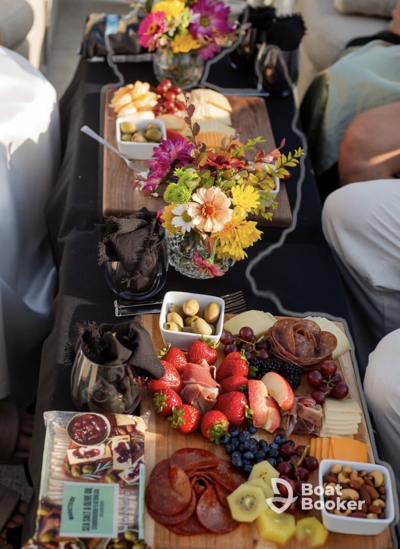 A beautifully arranged charcuterie board featuring fresh fruits, cheeses, and flowers, perfect for enhancing the onboard dining experience.