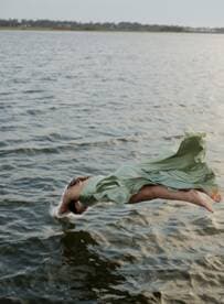 A person leaps gracefully into the water, capturing the thrill of summer fun and adventure on the water.