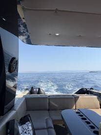 A cozy interior view of a boat's seating area, showcasing comfortable lounge space and scenic water views — perfect for relaxing while cruising.
