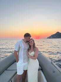 A couple shares a romantic moment on a boat at sunset, creating a perfect backdrop for love and celebration on the water.