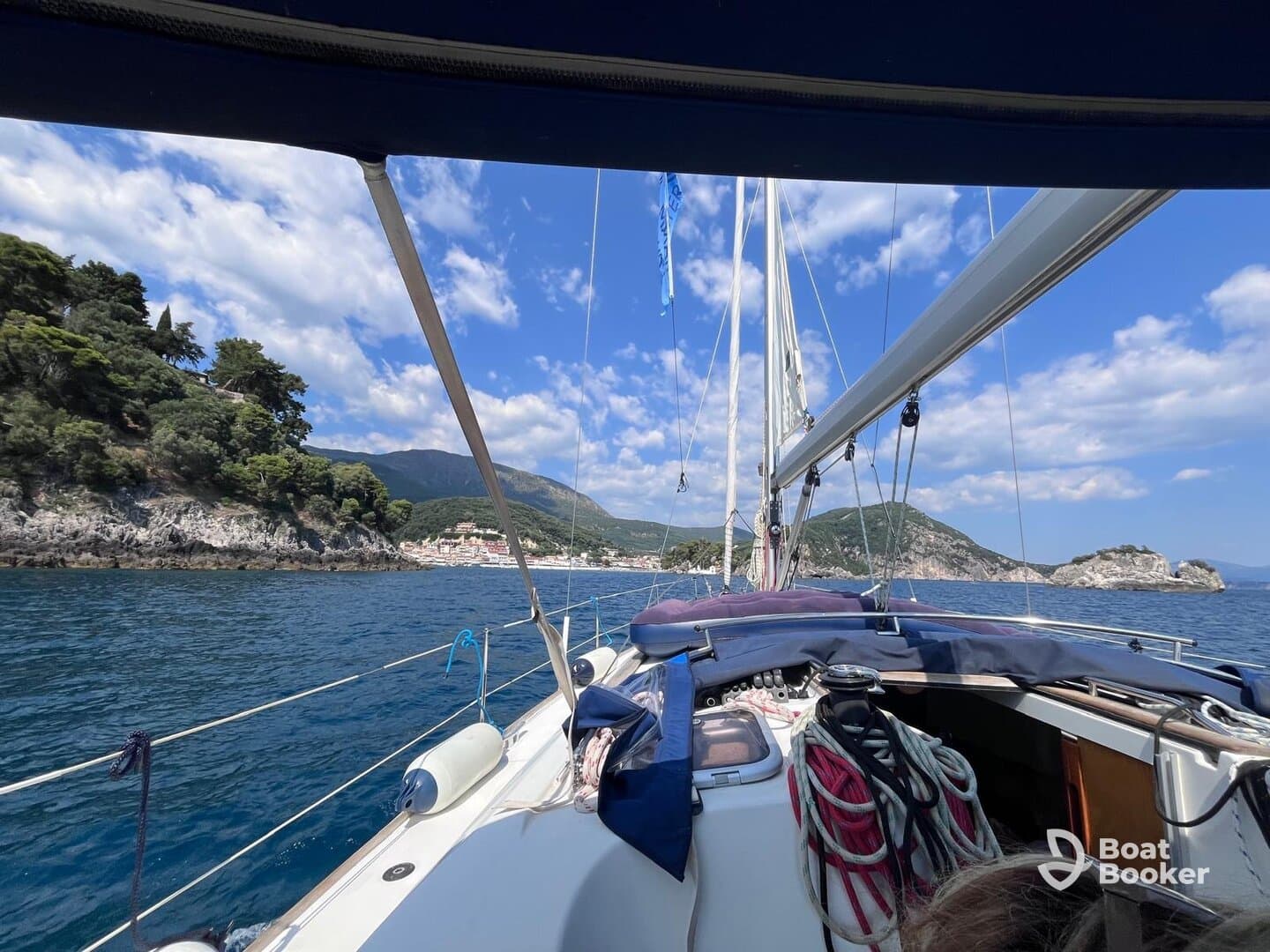 A scenic view from a sailboat, showcasing the beautiful coastline and lush greenery, perfect for sailing adventures and exploring picturesque destinations.