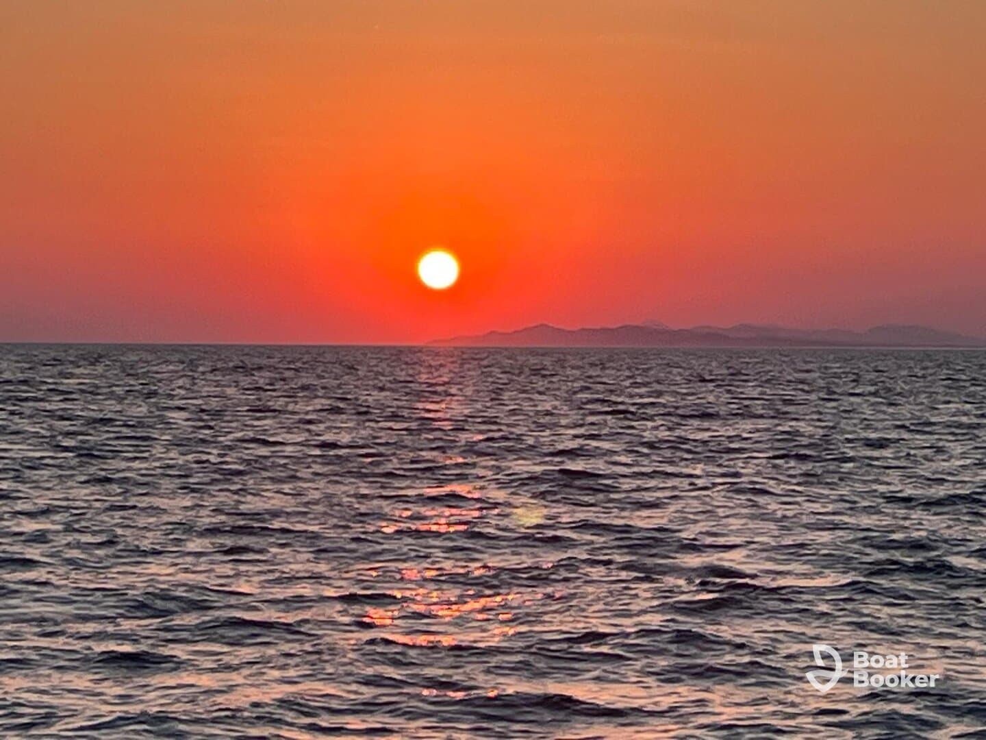 A stunning sunset over the ocean, casting vibrant colors across the water — a perfect backdrop for evening boat cruises.