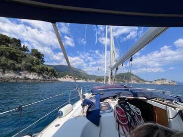 A scenic view from a sailboat, showcasing the beautiful coastline and lush greenery, perfect for sailing adventures and exploring picturesque destinations.