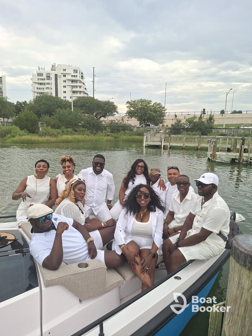 A lively group of friends dressed in white enjoys a fun day on the boat, perfect for celebrations and gatherings on the water.