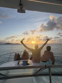 A group of friends celebrates at sunset aboard a yacht, raising their drinks in a toast — an unforgettable moment on the water.