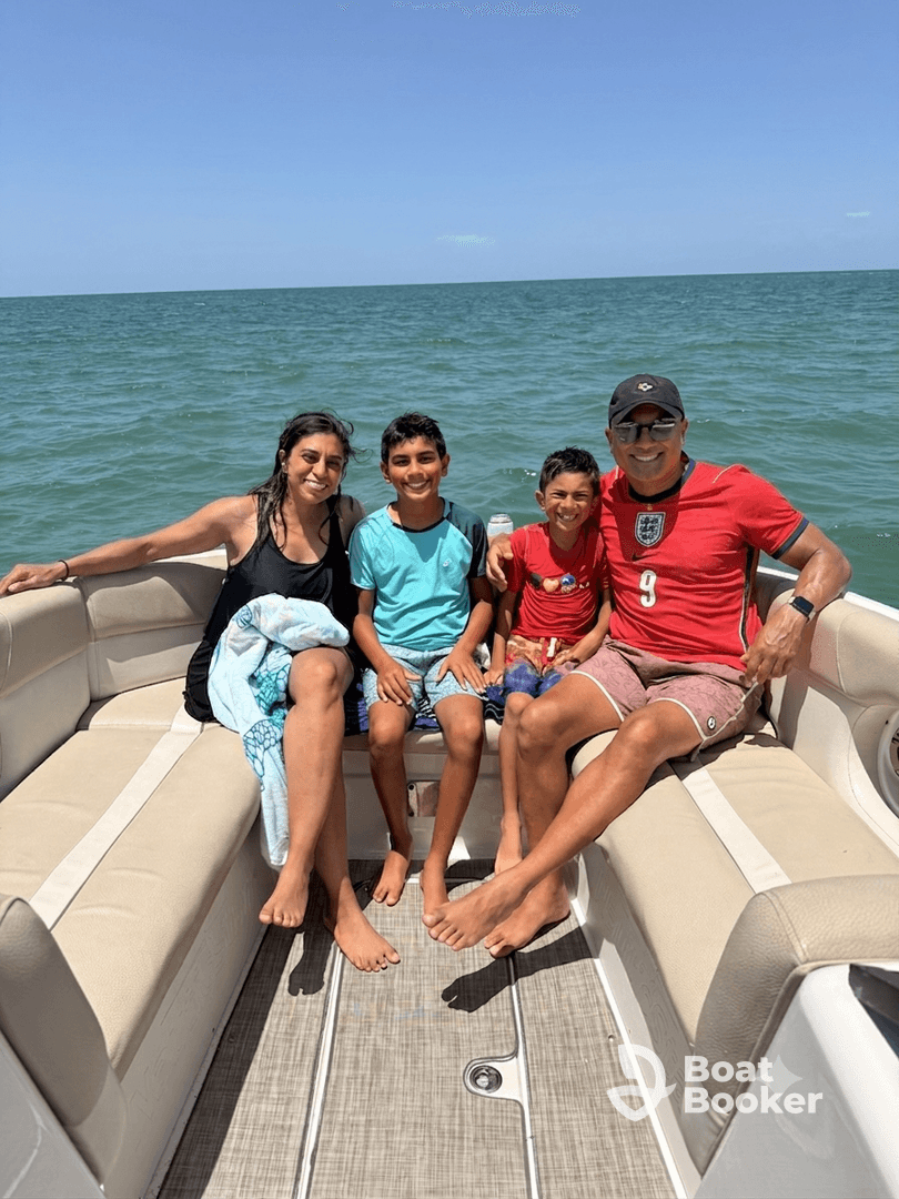 A joyful family enjoys a sunny day on a boat, capturing precious moments together on the water — perfect for family outings and adventures.