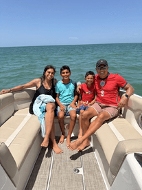 A joyful family enjoys a sunny day on a boat, capturing precious moments together on the water — perfect for family outings and adventures.