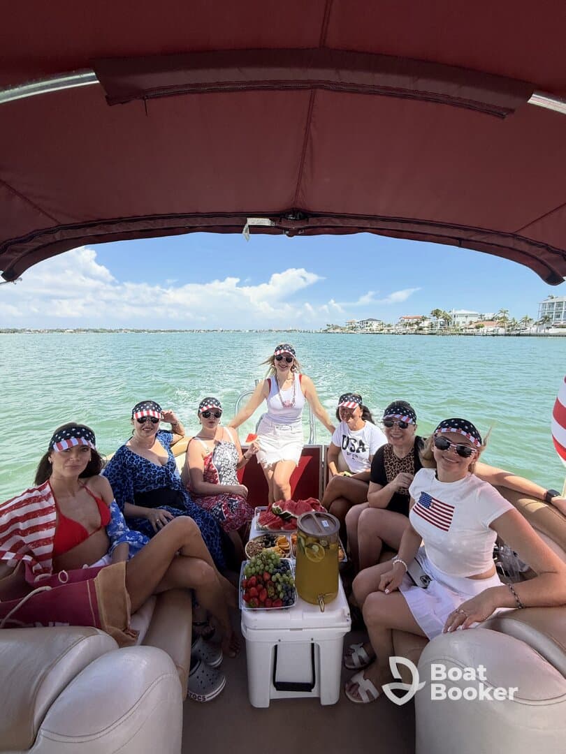 A lively group of friends enjoys a fun day on a pontoon boat, complete with delicious snacks and drinks, perfect for summer celebrations on the water.