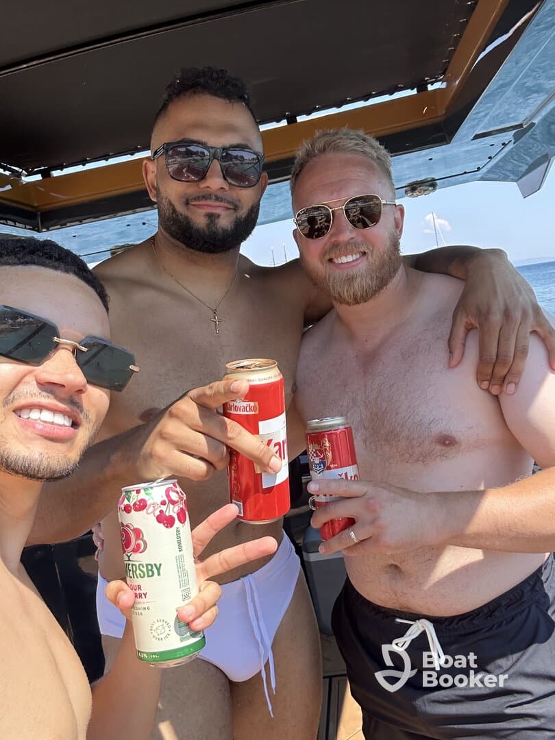 A group of friends enjoys drinks and celebrates aboard a boat, capturing the essence of a fun day on the water.