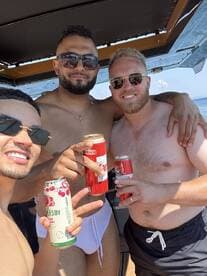 A group of friends enjoys drinks and celebrates aboard a boat, capturing the essence of a fun day on the water.