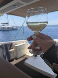 A guest enjoys a glass of wine aboard a yacht, capturing the essence of relaxation and celebration on the water.