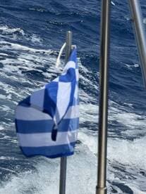 An unclear image featuring a flag against a backdrop of ocean waves, lacking identifiable subjects or context.