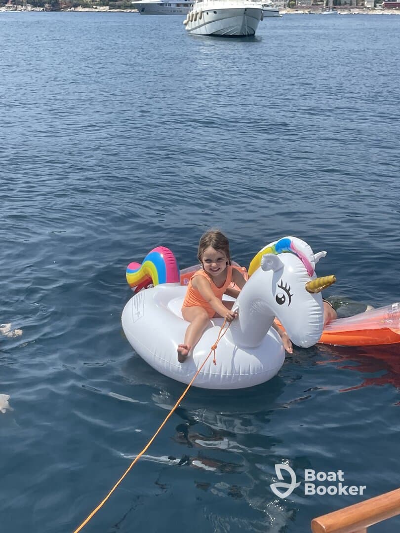 A joyful child enjoys a sunny day on a unicorn float in the water, capturing the essence of summer fun and family adventures.