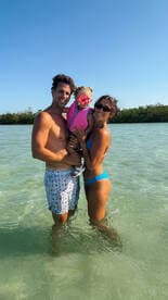A joyful family enjoys a sunny day in the water, creating lasting memories together — perfect for family vacations and beach outings.