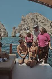 A lively group enjoys their time on a boat with stunning rock formations in the background, capturing the essence of a memorable adventure at sea.