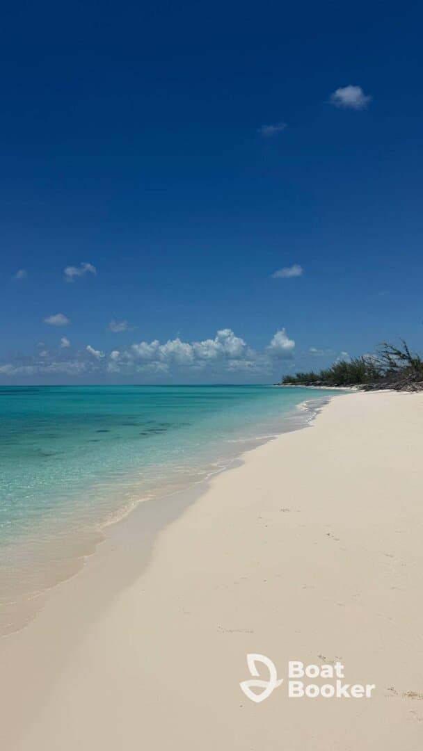 A stunning view of a pristine beach with soft white sand and crystal-clear turquoise waters, perfect for a relaxing getaway or beach day.