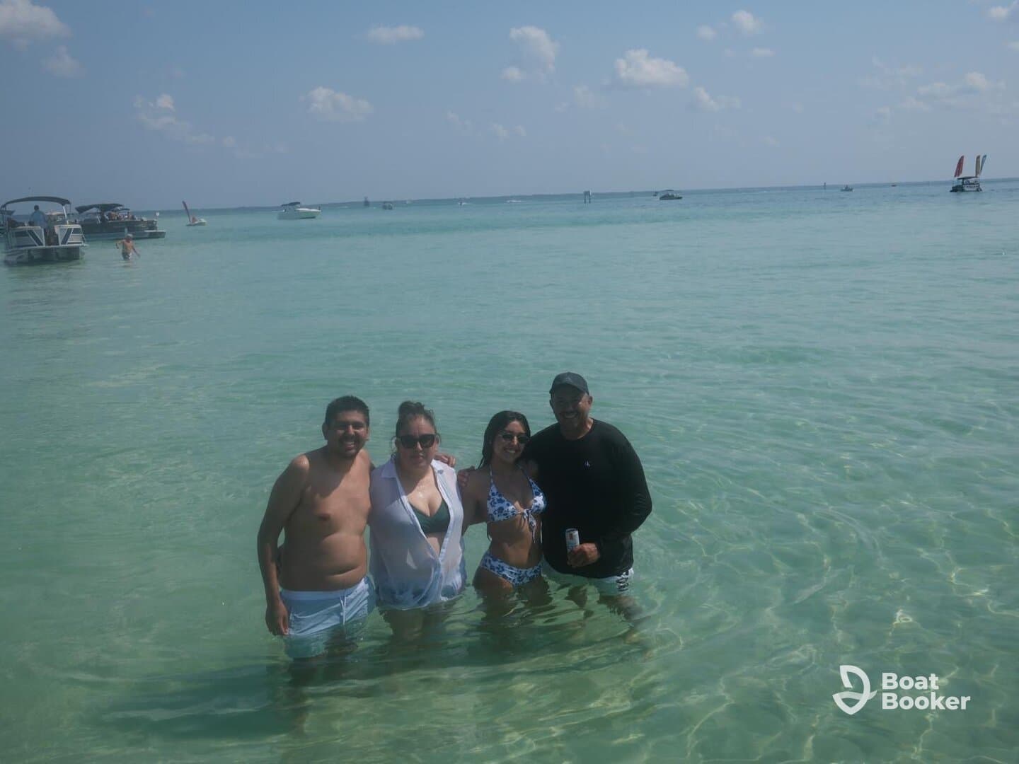 A lively group enjoys a fun day at the beach, swimming in clear waters and soaking up the sun — perfect for memorable summer outings.