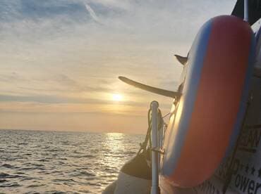 A serene sunset view from a boat, capturing the tranquil waters and the silhouette of the vessel — perfect for those seeking peaceful moments on the water.