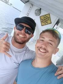 Two friends pose for a cheerful selfie on a boat, showcasing the fun and camaraderie of a day on the water.