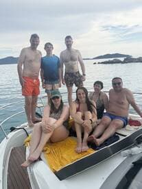 A cheerful group enjoys a day on the water, posing on the deck of a boat, perfect for family outings and summer adventures.
