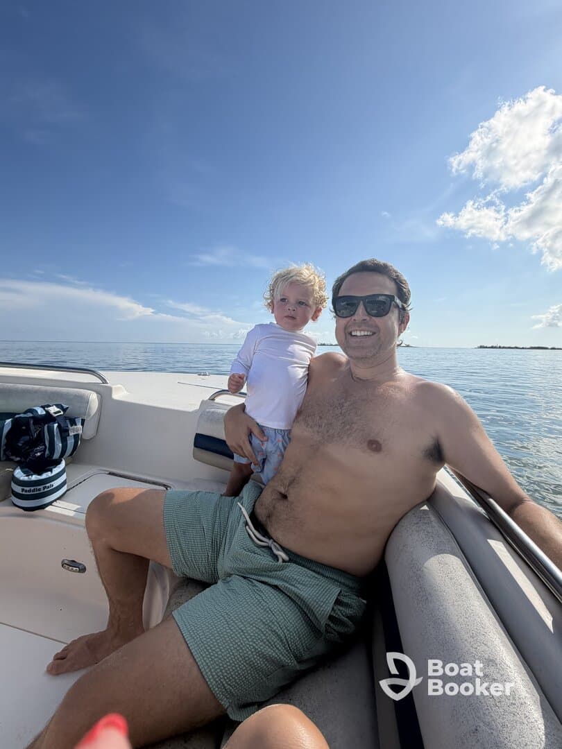 A joyful moment captured of a father and his young child enjoying a sunny day on the boat, perfect for family outings and creating lasting memories on the water.