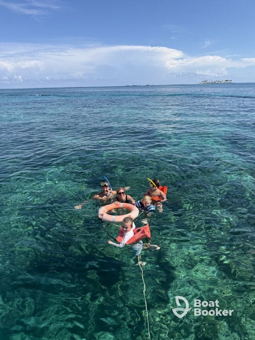 A joyful family enjoys snorkeling in crystal-clear waters, showcasing a perfect day of fun and adventure in the sun.
