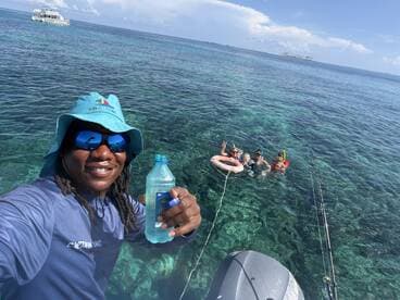 A joyful group enjoys snorkeling in crystal-clear waters, with a friendly guide capturing the moment. Perfect for family adventures and aquatic explorations.