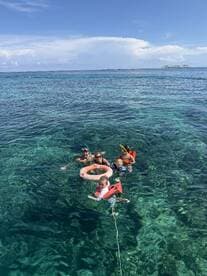 A joyful family enjoys snorkeling in crystal-clear waters, showcasing a perfect day of fun and adventure in the sun.