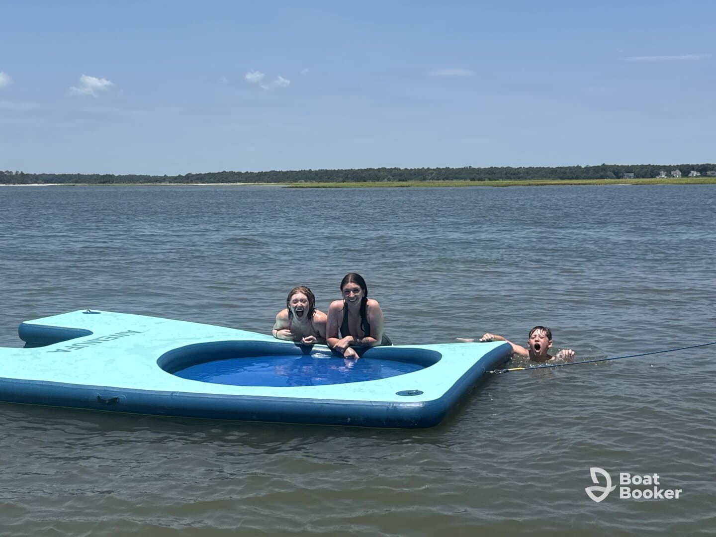 A group of kids enjoys a sunny day on a floating mat in the water, showcasing the fun of summer activities and family bonding.