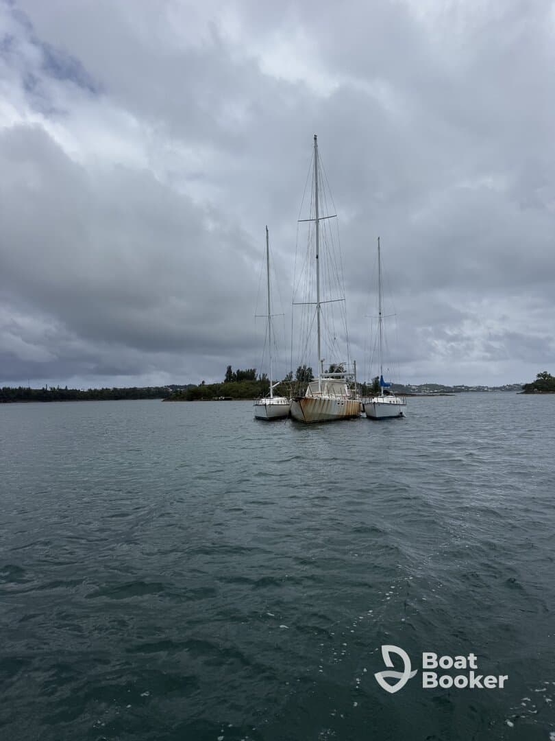 A serene view of a docked sailboat surrounded by calm waters and cloudy skies, perfect for showcasing nautical adventures.