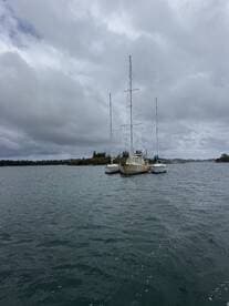 A serene view of a docked sailboat surrounded by calm waters and cloudy skies, perfect for showcasing nautical adventures.