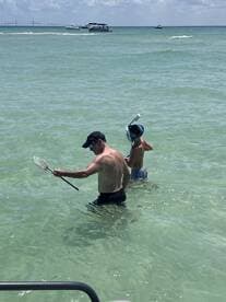 A father and son enjoy a fun day of snorkeling in clear waters, showcasing a perfect family adventure at the beach.