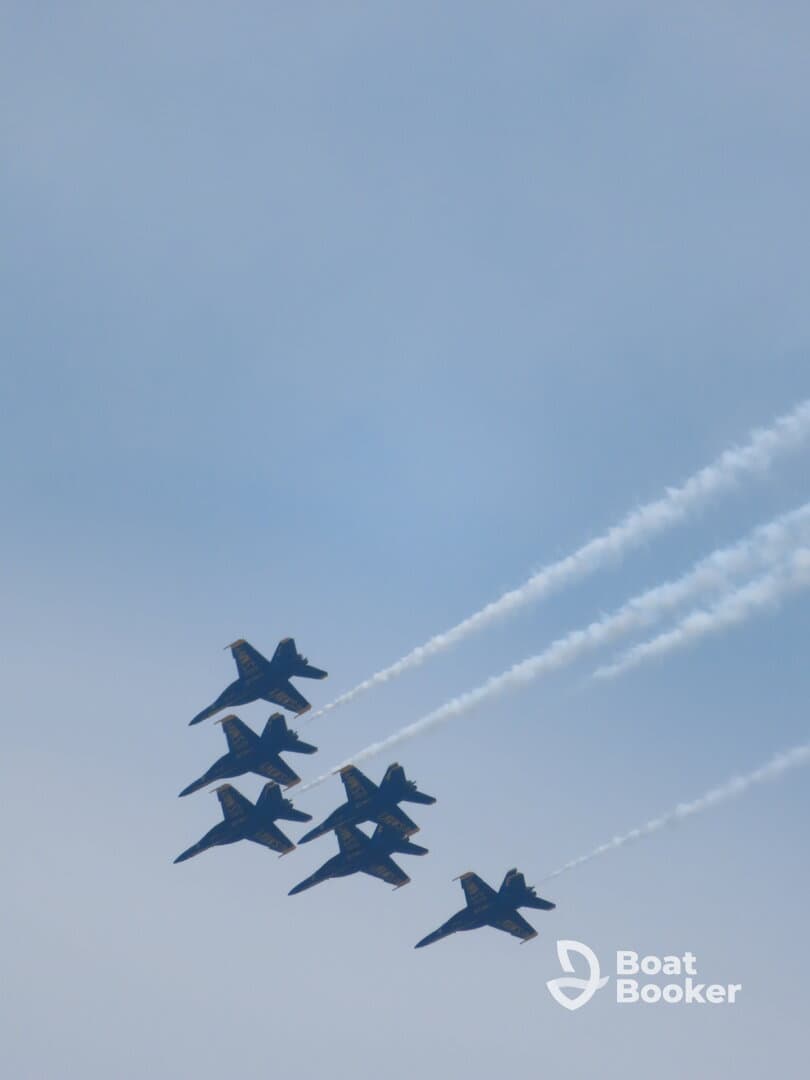 A formation of jets performing aerial maneuvers against a clear sky, showcasing precision flying.