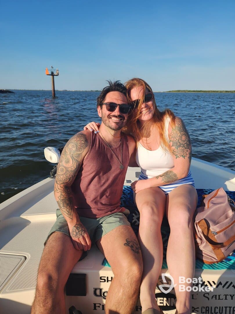 A happy couple enjoys a sunny day on the boat, capturing a perfect moment of joy and relaxation on the water.