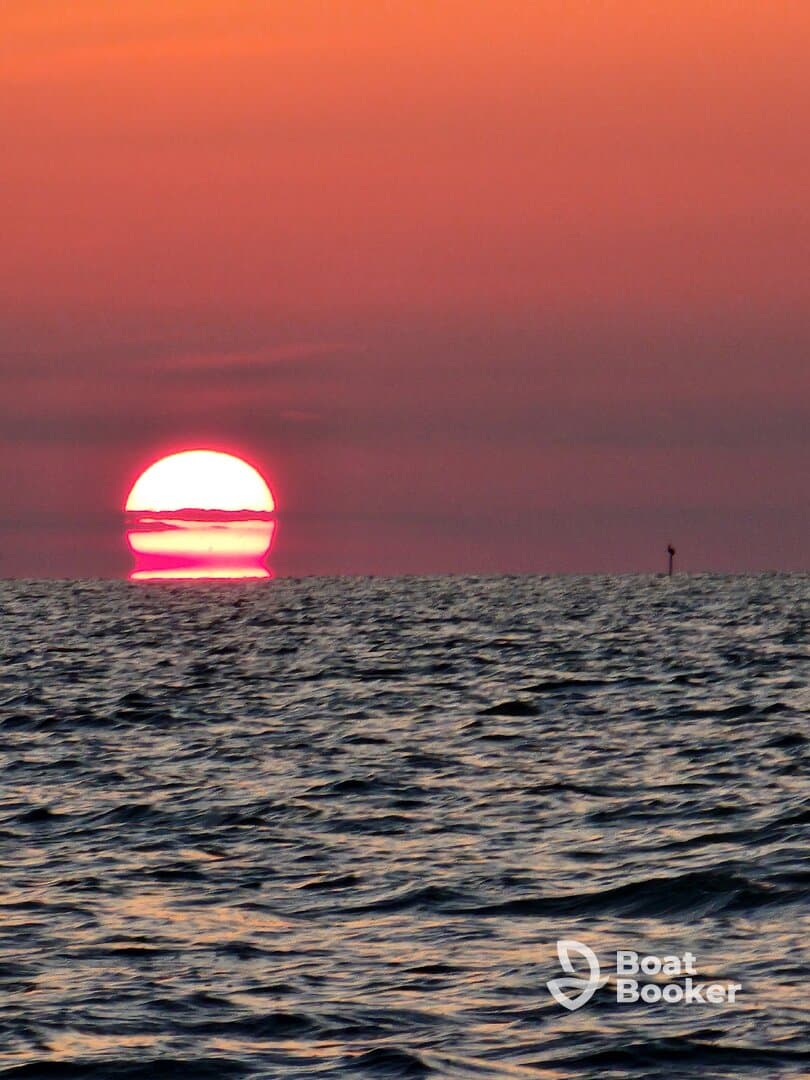 A breathtaking sunset over the ocean, showcasing vibrant colors and serene waters — perfect for capturing the beauty of nature during a boat trip.