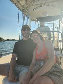 A happy couple enjoys a sunny day on the boat, capturing the essence of a perfect day on the water.